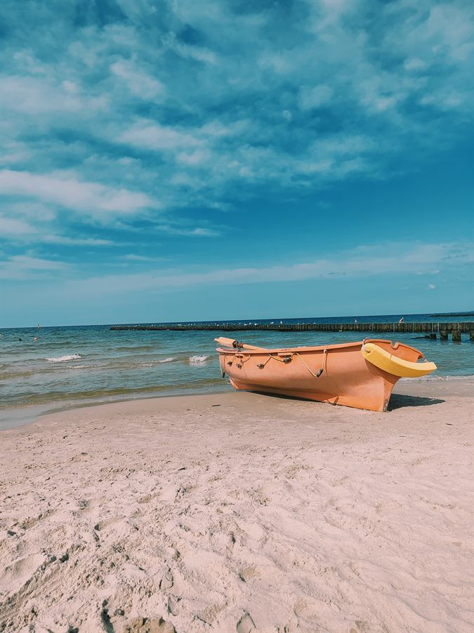 Piaszczysta plaża w Ustce z łodzią rybacką nad Bałtykiem